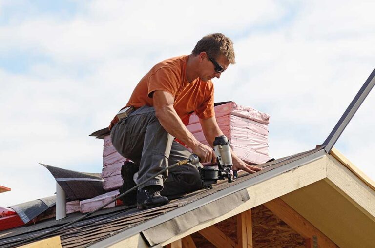 Residential homes with asphalt shingles, metal panels, and slate samples arranged beside a roof inspection.
